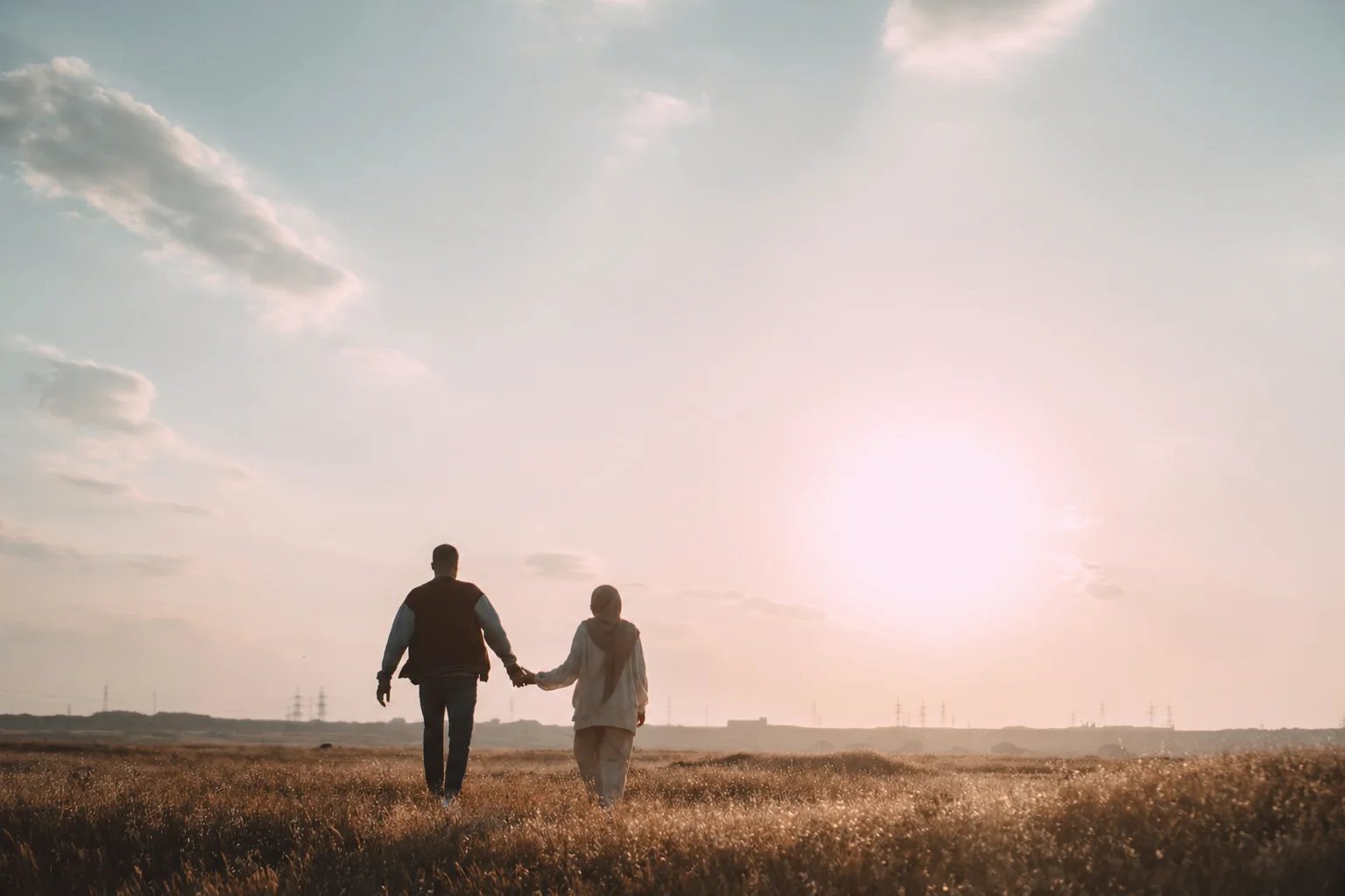 A Muslim couple walking together in a sunlit field — marriage in Islam